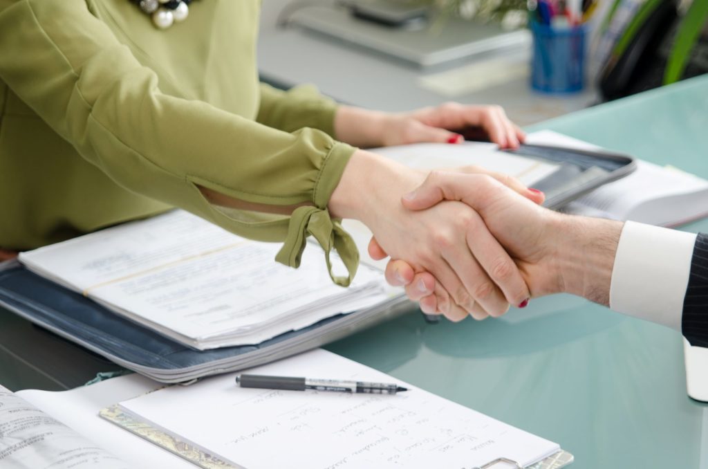 two people shake hands agree to a contract