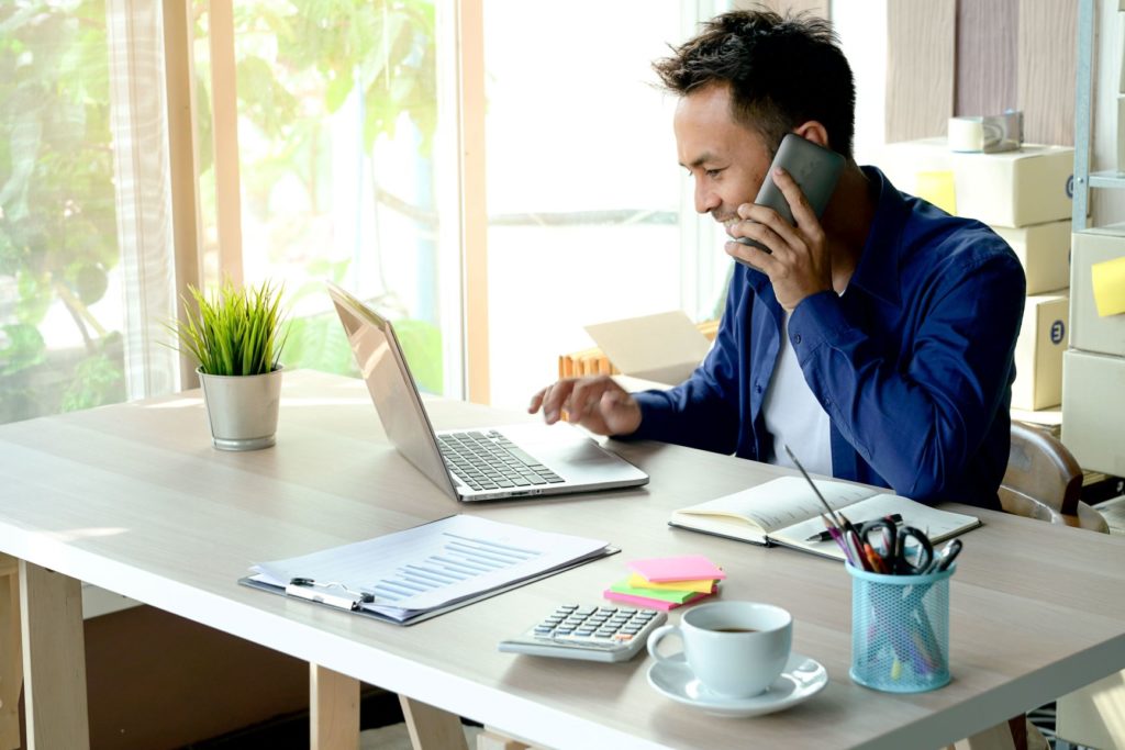The Contract of Insurance (A person in front of his laptop, on his phone chatting)