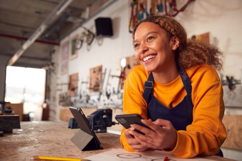 Insurance for your Side Hustle with AUZi (A girl smiling in a workshop)