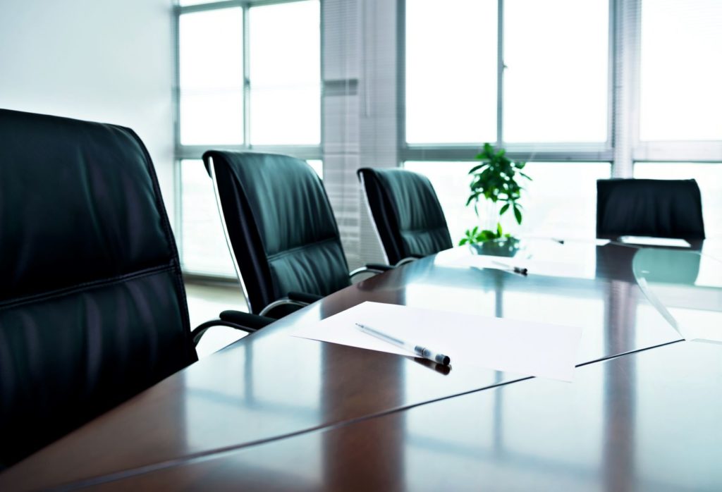 An empty boardroom with a pen and paper