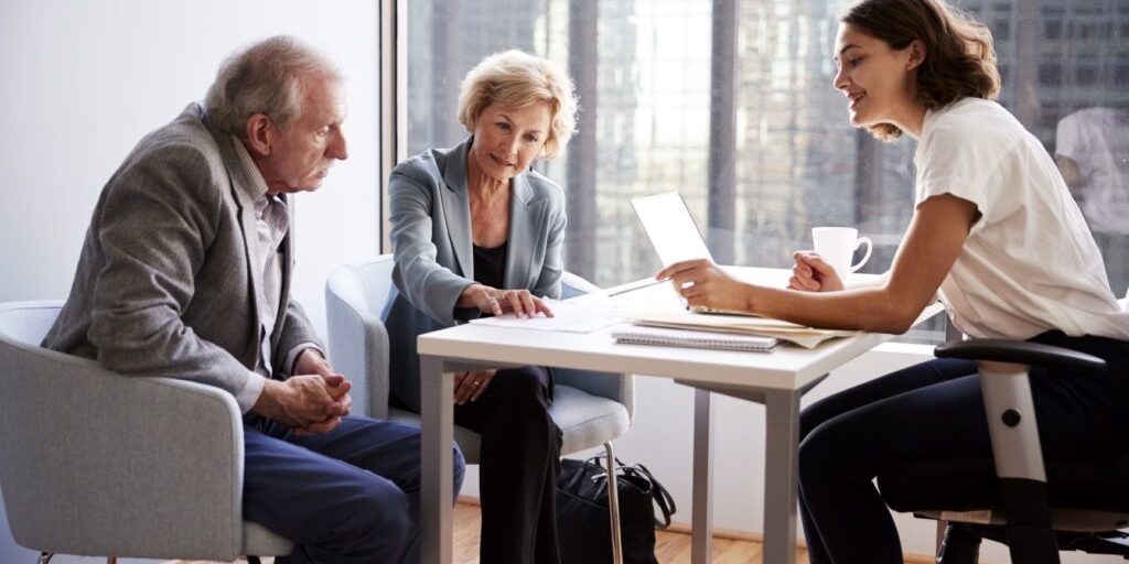 Why your client needs Professional Indemnity Insurance?(2 elderly couple in discussion with an insurance broker)