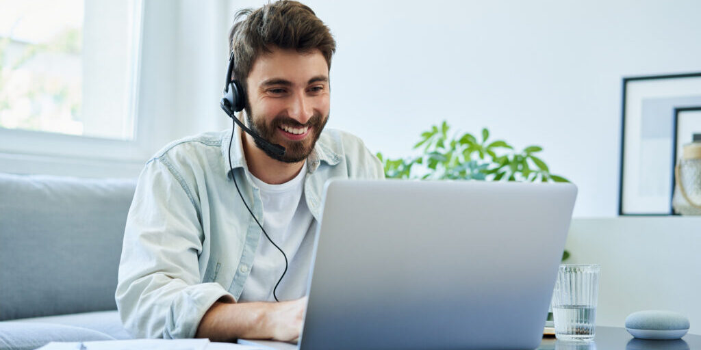 Young man with headset telecommuting