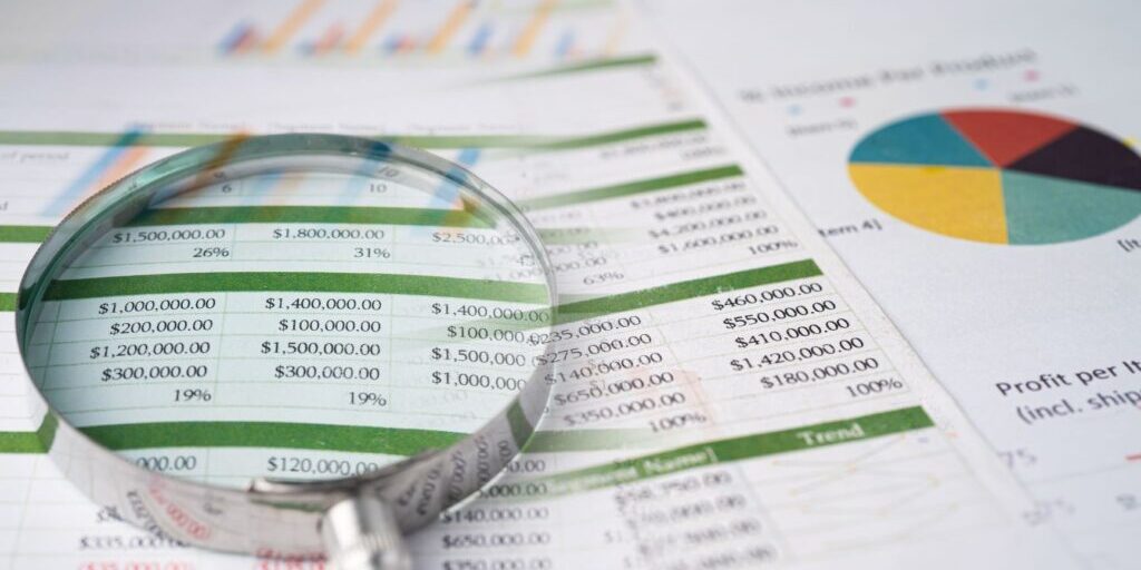 Financial reports on the desk with a magnification glass