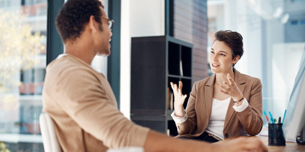 Mentor, training and a woman manager with an employee in the office for coaching on company vision. Management, meeting and a female business person talking to a professional male colleague at work.