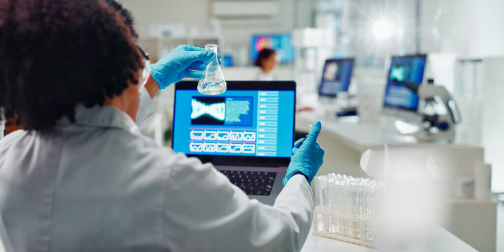 Lab, back and woman for science research, bio technology and gene mutation with laptop for data analysis. Bioinformatics, innovation study and beaker with chemical, life expansion and development.